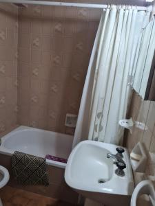 y baño con lavabo, bañera y cortina de ducha. en Sur XII 12C en Miramar