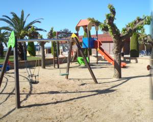 a playground with a slide in the sand at Albatross Mobile Homes on Camping El Pla de Mar in Malgrat de Mar