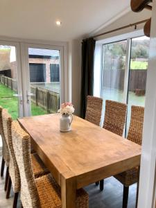 a wooden table with chairs and a vase of flowers on it at ValleyView Cottage-Cosy, Rustic Home - Log Burner in Ushaw Moor