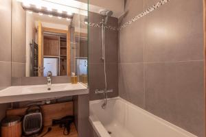 a bathroom with a sink and a tub and a mirror at Val Thorens - Cosy Duplex avec Vue Silveralp 337 in Val Thorens +20 photos