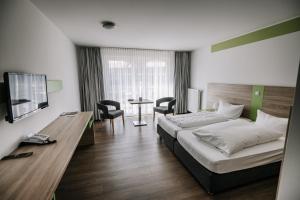 pokój hotelowy z łóżkiem, stołem i krzesłami w obiekcie Gut Gremmelin w mieście Gremmelin