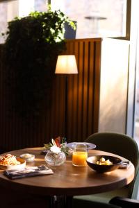 drewniany stół z jedzeniem i sokiem pomarańczowym na nim w obiekcie Lecco Hotel w mieście Mytiszczi