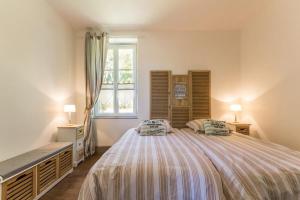 a bedroom with a large bed and a window at Les Barboulottes in Châtillon-en-Bazois