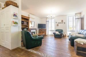 a living room with two green chairs and a couch at Les Barboulottes in Châtillon-en-Bazois