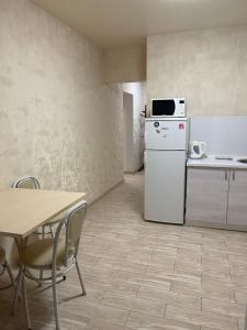 uma cozinha com um frigorífico branco e uma mesa em 020 Новые апартаменты ЖК «Софиевская Слободка» em Vyshneve