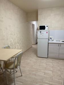 a kitchen with a white refrigerator and a table at 020 Новые апартаменты ЖК «Софиевская Слободка» in Vyshneve