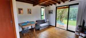 a living room with a couch and a table at IbiraCottage in Imbituba