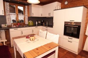 una cocina con armarios blancos y una mesa con un tazón. en Ferienwohnung Sternschnuppe, en Chieming