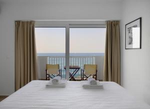 a bedroom with a bed with a view of the ocean at Sea Breeze Hotel in Hersonissos