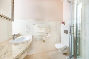 ein Bad mit einem WC, einem Waschbecken und einer Dusche in der Unterkunft Willa Carlton in Zakopane
