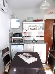 una pequeña cocina con mesa y microondas en Monoambiente San Lorenzo en San Rafael