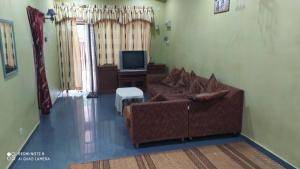 een woonkamer met een bank en een tv bij Aqil Homestay Lunas Kulim for Mslim only in Lunas