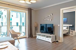 ein Wohnzimmer mit einem Flachbild-TV und einem Sofa in der Unterkunft Strandkorb Nr. 7 in Rostock