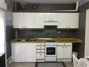 una cocina con armarios blancos y fregadero en LA PAJARITA, en La Franca