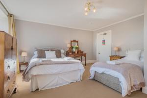 a bedroom with two beds and a dresser at Big Pink House in Mealsgate