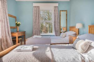 a bedroom with two beds and a window at Big Pink House in Mealsgate