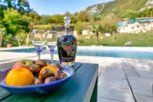 una botella de vino y un tazón de frutas y copas de vino en Villa Valentina, en Bribir
