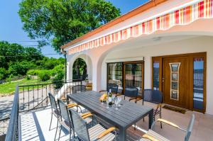 Un patio con una mesa y sillas en un balcón. en Villa Valentina, en Bribir