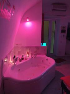 Habitación con baño rosa con bañera. en La Suite del Brigante, en Gioia del Colle