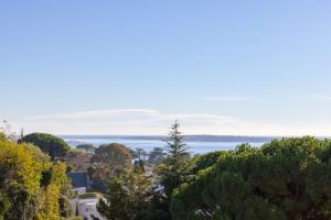 uma vista para o oceano de uma colina com árvores em SERRENDY Splendid 3-bedroom apartment em Cannes
