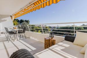 um quarto com uma varanda com uma mesa e cadeiras em SERRENDY Splendid 3-bedroom apartment em Cannes