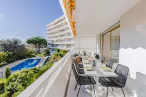 uma varanda com uma mesa e cadeiras e uma piscina em SERRENDY Splendid 3-bedroom apartment em Cannes