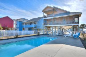 a house with a swimming pool in front of a house at Just Peachy in Oak Island