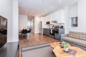 Il comprend un salon et une cuisine avec un canapé et une table. dans l'établissement Vast and perfectly located 3 bedroom flat by DenStays, à Montréal