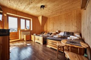 a bedroom with two beds and a table in it at Pod Strumykiem in Czarny Dunajec