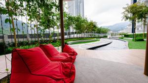 a red couch sitting on a patio with a pond at Double Story in the Sky - Genting Windmill Duplex Suite in Genting Highlands