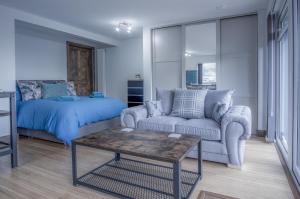 ein Wohnzimmer mit einem Sofa und einem Bett in der Unterkunft Haylands Hideaway - 1 Bedroom Apartment - Jameston in Manorbier