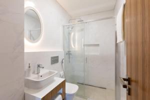a white bathroom with a sink and a shower at Correeira Luxury Residence in Albufeira