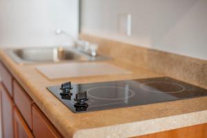 un bancone da cucina con lavello e fornello di WoodSpring Suites Williston a Williston Altre 11 foto