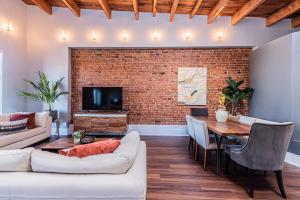 a living room with a brick wall and a table at Family Friendly 3-bedroom beauty in Le Plateau by DenStays in Montréal