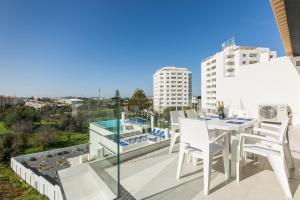 balcón con mesa, sillas y vistas en Correeira Luxury Residence, en Albufeira