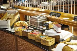 a bakery with a counter with food on it at Holiday Inn Gent Expo, an IHG Hotel in Ghent