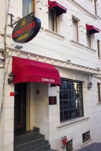 a longstay restaurant with a red awning on a building at Long Stay İstanbul Hotel in Istanbul