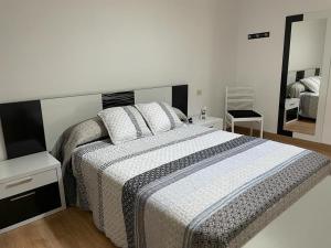 ein Schlafzimmer mit einem großen Bett und einem Spiegel in der Unterkunft A casa Daló in Folgoso