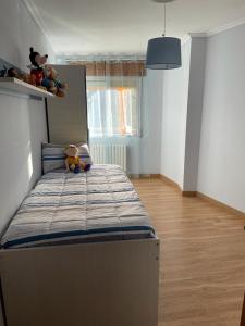 ein Schlafzimmer mit einem Bett mit einem Teddybär drauf in der Unterkunft A casa Daló in Folgoso