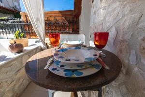 a table with a plate and two wine glasses at Nymphes House Pefkochori in Pefkohori