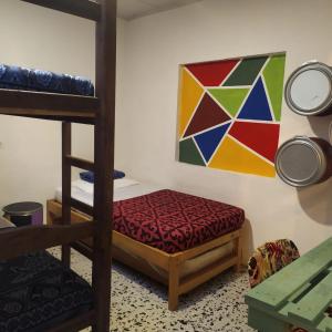 a bedroom with a bunk bed and a colorful painting at Hostal Macondo Inn in Carmen de Viboral