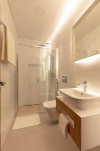 a white bathroom with a sink and a shower at Correeira Luxury Residence in Albufeira
