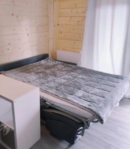 Cama en habitación con pared de madera en Studio tout confort avec vue sur les sommets en Combloux