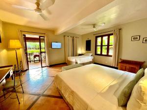 a hotel room with two beds and a television at La Palmeraie D'angkor in Siem Reap