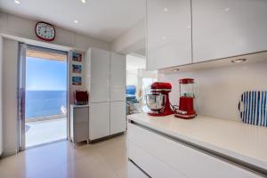 埃茲的住宿－Villa Eze Vue Mer，柜台上配有红色用具的厨房