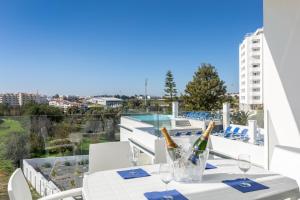a white table with two bottles of wine on a balcony at Correeira Luxury Residence in Albufeira