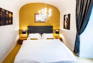 a bedroom with a white bed and a chandelier at Silvie Apartments - Blažejský in Olomouc