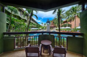 a balcony with a table and chairs and a swimming pool at Phuket Island View Resort - SHA Extra Plus in Karon Beach
