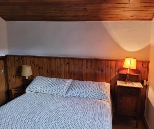 a bedroom with a bed with a wooden head board at Can Serraima, Casa rural a prop de la Cerdanya in Nevà +24 photos