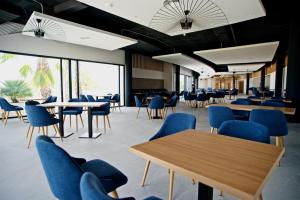 eine Cafeteria mit blauen Stühlen, Tischen und Fenstern in der Unterkunft Syncrosfera Fitness & Health Hotel Boutique in Pedreguer